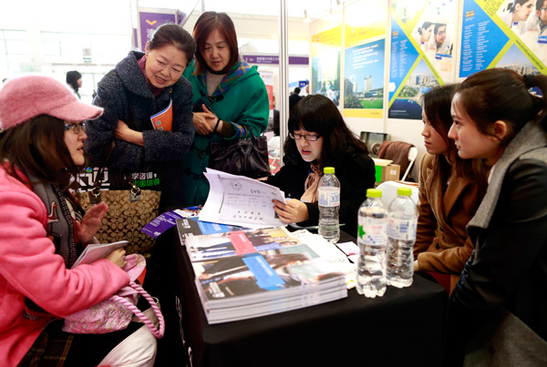 A student (far left) visits a booth for Australian universities at the 19th China International Education Exhibition Tour in Beijing on Sunday. FENG YONGBIN / CHINA DAILY
