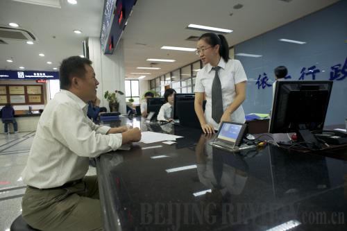 ONE-STOP SERVICE: A company manager (left) handles a registration procedure at the Shanghai Administration for Industry and Commerce in November 2013 reform (WU ZIXI)