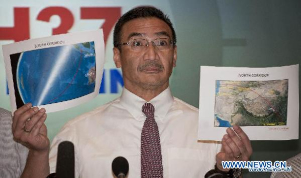 Malaysia's acting Transport Minister Hishammuddin Hussein shows two satellite maps of the possible location of the missing Malaysia Airlines flight MH370 in Kuala Lumpur, Malaysia, March 17, 2014.  (Xinhua/He Jingjia)