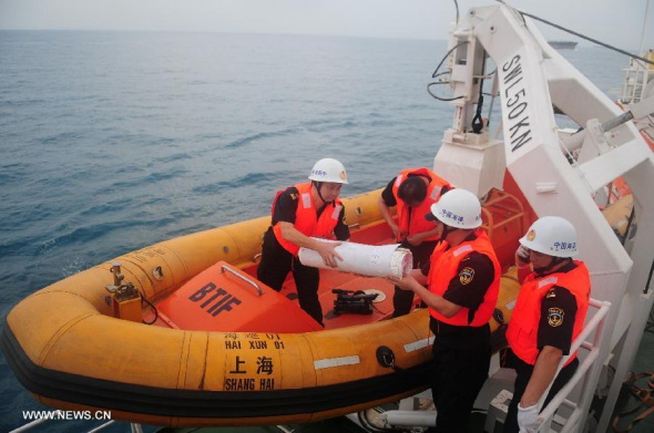 Staff members of rescue vessel Haixun 01 board a boat to deliver marine charts to rescue vessel Nanhaijiu 101 on March 19, 2014. Nine vessels, including China's largest rescue ship Haixun 01, will sail off from Singapore to waters southeast of the Bay of Bengal and west of Indonesia, covering an area of 300,000 square kilometers, said the national maritime search and rescue center. (Xinhua/Chen Weiwei)