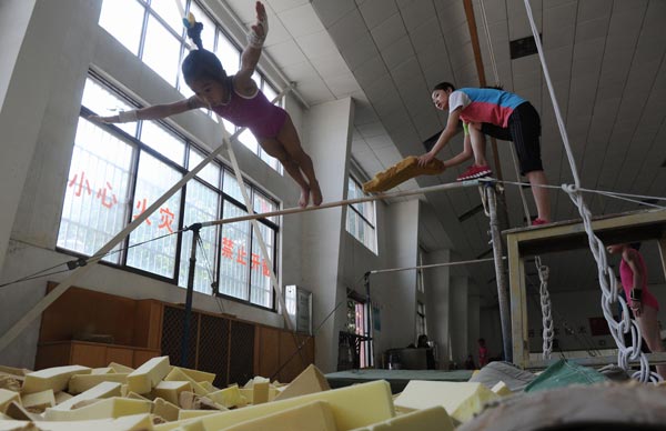 A teacher instructs a young athlete at the Hunan Provincial Gymnastics Sports School. YANG HUAFENG / CHINA NEWS SERVICE