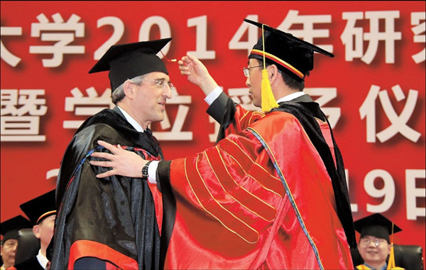 Yale University president Peter Salovey is presented with an honorary doctorate by Zhang Jie, president of Shanghai Jiao Tong University yesterday.  Zhang Suoqing 