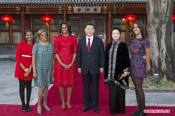 Chinese President Xi Jinping (3rd R) and his wife Peng Liyuan (2nd R) pose for a group picture with U.S. First Lady Michelle Obama (3rd L), Michelle's mother Marian Robinson (2nd L), Michelle's daughters Malia (1st R) and Sasha (1st L) during their meeting in Beijing, capital of China, March 21, 2014. (Xinhua/Huang Jingwen)