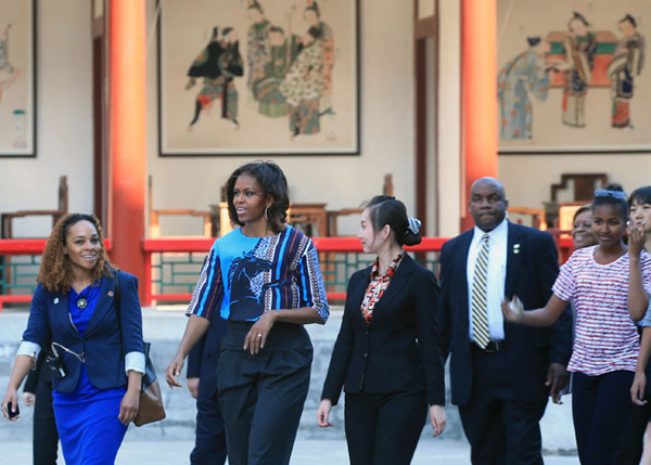 US first lady Michelle Obama (2nd L) walks with staff members as she and her daughters Malia and Sasha visit the Summer Palace in Beijing, March 22, 2014. US first lady met her Chinese counterpart on Friday, a long-anticipated encounter during a week-long trip to promote education and cultural ties.[Photo by Wang Jing/China Daily]