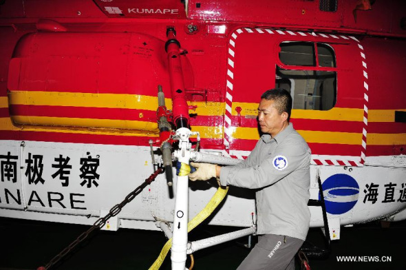 Crew members examine helicopters to prepare for the search of the missing Malaysia Airlines Flight MH370 on Chinese icebreaker Xuelong, March 24, 2014. Chinese icebreaker Xuelong has changed its course towards the latest sighting of some suspicious objects spotted by the crew aboard a Chinese IL-76 plane. Xuelong is expected to reach the area in the southern Indian Ocean in the early hours of Tuesday. (Xinhua/Zhang Jiansong)