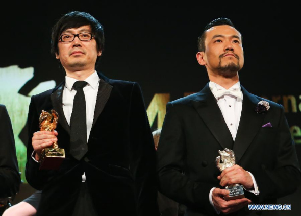 Director Diao Yinan (L) of Black Coal, Thin Ice , winner of the Golden Bear for the Best Film, and Liao Fan, winner of the Silver Bear for Best Actor for Black Coal, Thin Ice, pose for photos during the awards ceremony at the 64th Berlinale International Film Festival in Berlin, Feb. 15, 2014