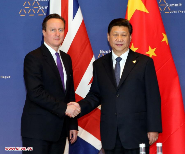 Chinese President Xi Jinping (R) meets with British Prime Minister David Cameron in The Hague, the Netherlands, March 25, 2014. (Xinhua/Liu Weibing)  