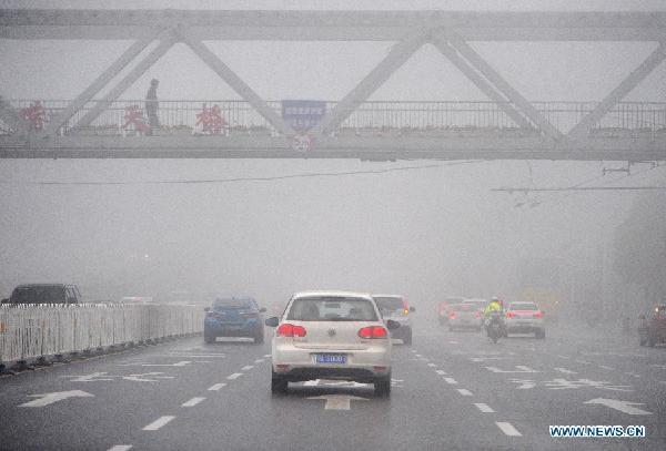 Vehicles run amid fog in Wuhan, capital of central China's Hubei Province, March 26, 2014. A heavy fog shrouded the city Wednesday, reducing the visibility to less than 500 meters. The local meteorological bureau issued a yellow alert for fog. (Xinhua/Xiao Yijiu)