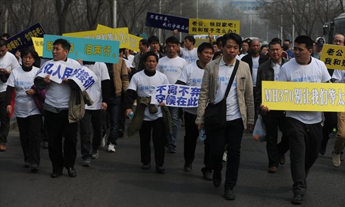 Relatives of Chinese passengers on board MH370 march toward the Malaysian Embassy in Beijing on Tuesday. Photo: Li Hao/GT