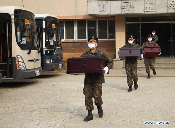 South Korean soldiers carry to vehicles coffins containing remains of Chinese soldiers dead in the Korean War, in Paju, South Korea, March 27, 2014. The remains of 437 Chinese soldiers were transported from Paju to Incheon Airport on Thursday. They will be flown back to China after a handover ceremony at Incheon Airport on March 28. (Xinhua/Yao Qilin)