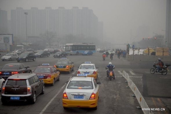 Vehicles run on a road in smog in Beijing, capital of China, March 27, 2014. (Xinhua/Li Xin)