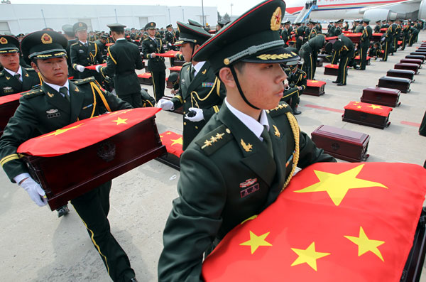  Soldiers of the Chinese People's Liberation Army carry coffins containing the remains of 437 soldiers of the Chinese People's Volunteers who were killed in the Korean War (1950-53). The remains arrived at Shenyang Taoxian International Airport on Friday. Zhang Wei / China Daily
