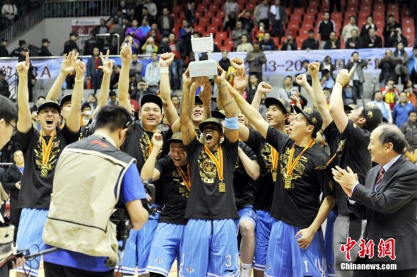 Beijing Ducks players celebrate after upsetting hosts Xinjiang Guanghui 98-88 on Sunday in Urumqi, winning their second Chinese Basketball Association (CBA) title in the past three years. (Photo: Chinanews.com)