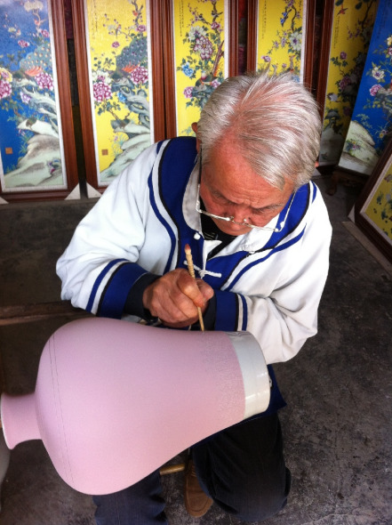 Ceramic artists carve decorative patterns on a semi-finished ceramic pot, in the Jingdezhen Ancient Kiln Folk Custom Expo Area, Jiangxi province.(Photo/Zhou Yunayuan)