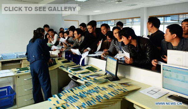 Citizens wait to get car plates in Hangzhou, capital of east China's Zhejiang Province, March 25, 2014. 