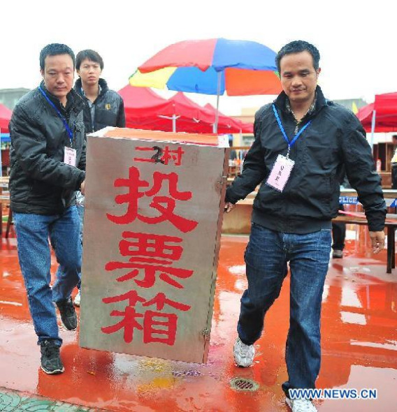 Working staff carry the ballot box after the village committe election of Wukan Village in Lufeng City, south China's Guangdong Province, March 31, 2014. Thousands of residents of Wukan cast votes to select a seven-member village committee on Monday. Wukan was thrown under the international spotlight in 2011 when its residents staged three waves of large-scale rallies in four months against village officials' alleged illegal land grabs, corruption and violations of financing and election rules. A re-election, hailed as a national tryout of self-governance and a promotion of the spirit of democracy and the rule of law, was held in March 2012. (Xinhua/Lu Hanxin)