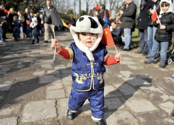 A child waits for the arrival of giant pandas Xing Hui and Hao Hao in Brussels. Photo provided to China Daily