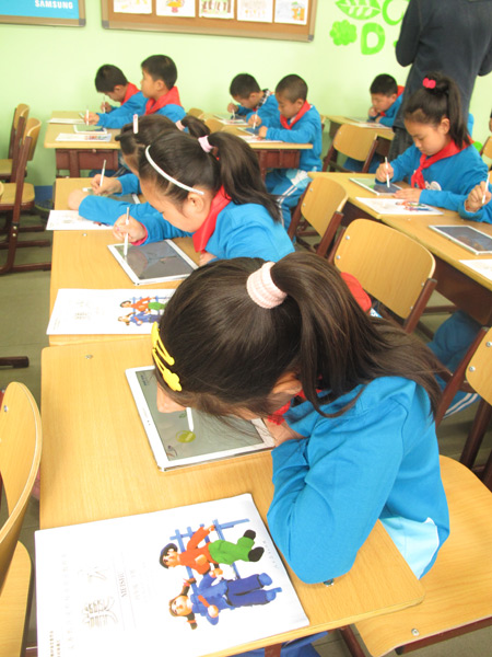 Students at Mingyuan School draw pictures on Samsung tablets during an arts lesson on April 1. Photo by WANG KAIHAO 