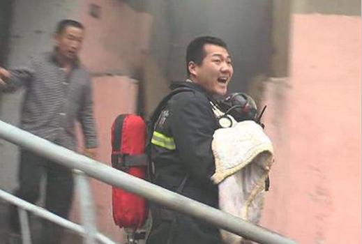 A firefighter’s gas mask covers the face of an 8-month-old baby rescued from a residential fire on Sunday in Xuzhou City, Jiangsu Province.