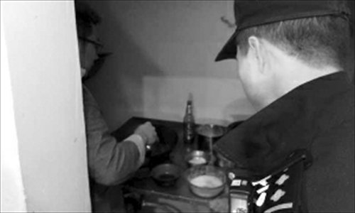 A police officer questions the man suspected of crashing a Mercedez-Benz into a row of parked cars as he cooks at a nearby restaurant.