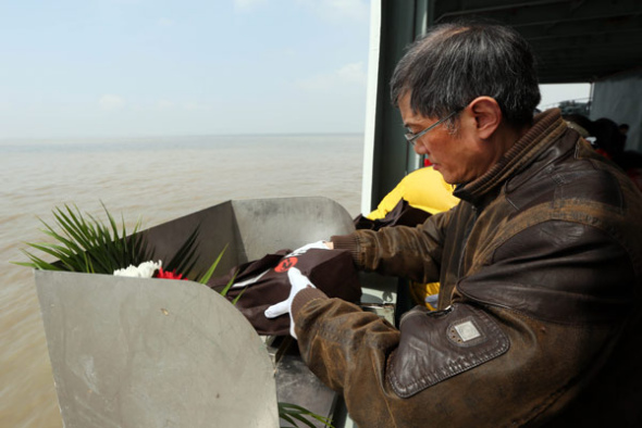 A man prepares to scatter the ashes of his dead relative in the sea off Nantong, Jiangsu province, on Tuesday. [Xu Peiqin/for China Daily]