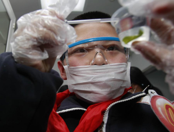 A student checks food samples at a laboratory set up at a Carrefour supermarket in Shanghai in March to learn more about food safety. Last year, prosecutors nationwide dealt with 5,184 major cases, with 80 percent of them involving food and drug safety or the environment. [Photo/Xinhua] 