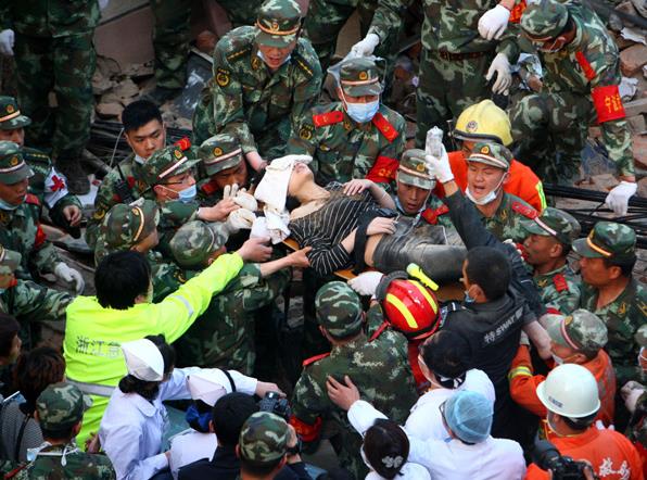 Rescuers carry 21-year-old Shen Dailu from the rubble on Friday afternoon after a residential building collapsed in Fenghua, Zhejiang province, in the morning. [Photo by Zhang Peijian/for China Daily] 