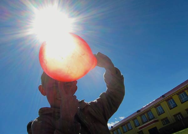 A boy plays with a balloon in the grounds of Yege primary school in the remote nomadic community of Yushu prefecture in Qinghai province. PHOTOS BY ERIK NILSSON / CHINA DAILY