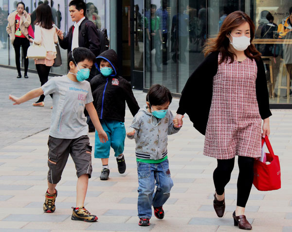 A mother with her three boys wearing respirators in Sanlitun village, Chao Yang district, Beijing, April 8. Photo provided for China Daily