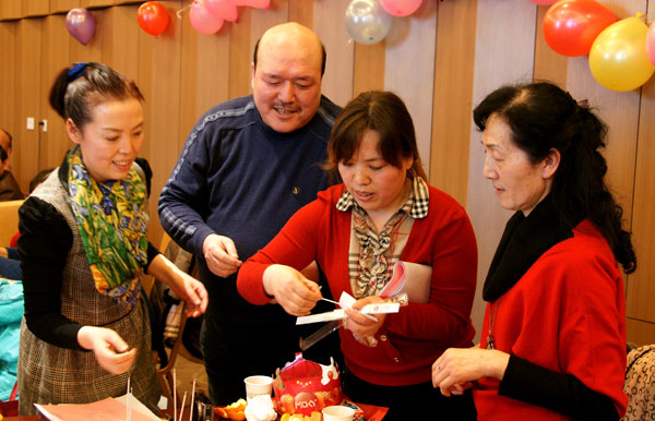 Ye Xiaoling (first left) director of the family planning bureau of Weiyang district in Xi��an, and colleagues prepare a birthday party for bereaved parent Xue Mingxin (second left). PROVINDED TO CHINA DAILY