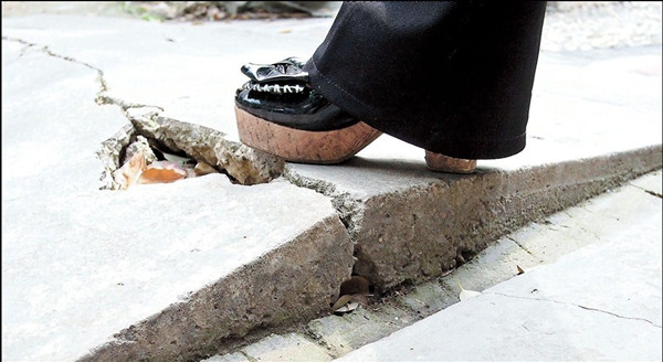 Huge cracks can be seen on the pavement of a residential building in Shiliuyuan Community on Luyang Road in Putuo District. The district government yesterday promised to repair the damage and fix the cracks, which the more than 400 residents of the building have blamed on the Metro Line 11. — Dong Jun