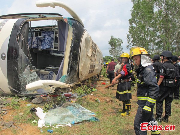 A bus carrying more than 40 primary school students flip over on its way to a scenic spot during a spring outing in Wenchang, Hainan province, on April 10, 2014. At least 8 students were killed in the accident. [Photo: China News Service/Fu Meibin]