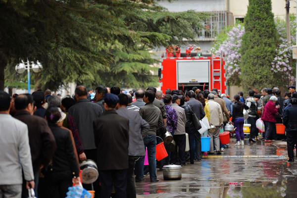 Residents queue up to get safe water supplied by the government in Lanzhou, Gansu province on Friday after the city's tap water was found to be polluted by benzene, a toxic cancer-causing chemical. [Photo/Xinhua]