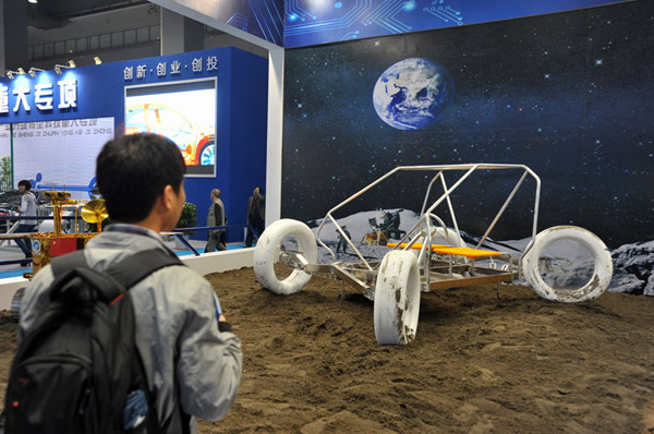 Visitor inspects a lunar rover at the 11th China Chongqing High-tech Fair on Thursday. The rover is expected to serve the nation's first astronauts who will set foot on the moon. [Photo/China Daily]