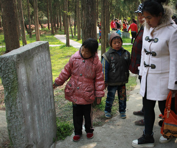 Visitors read the epitaph on the gravestone of the Japanese soldiers buried in the cemetery.