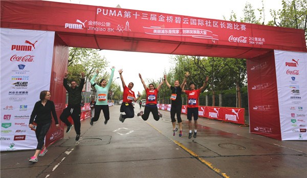 Some foreign participants of the community running event Puma Jinqiao 8K jumped at the starting point before the competition kicked off in Shanghai on Sunday. Photo provided to China Daily.