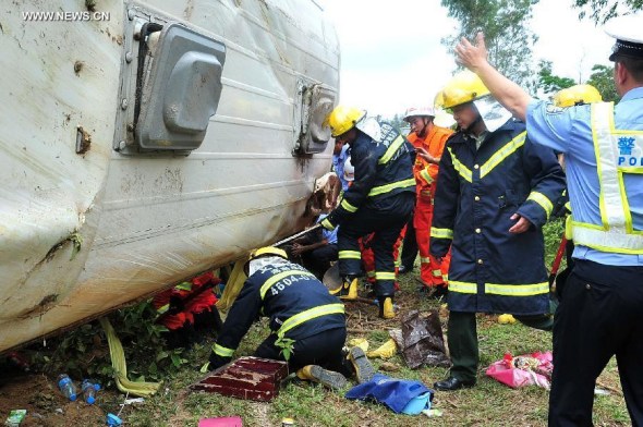 Rescuers work at the accident site after a bus for spring-outing overturned in Dongge township of Wenchang city, south China's Hainan province, April 10, 2014. [Photo /Xinhua]