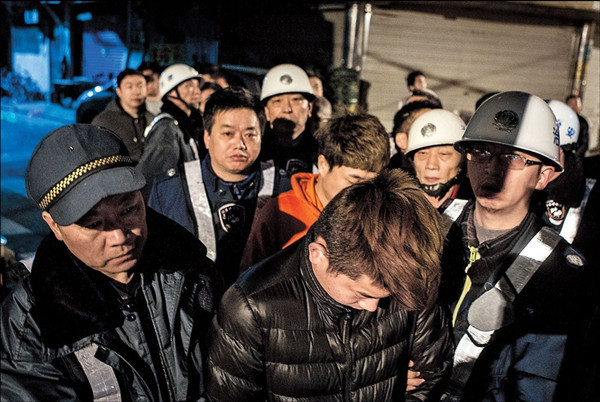 Members of the crime gang are led away after a raid on a hostel on Zhejiang Road. — Yang Shenlai 