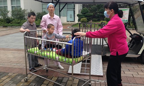 Caretakers transport the homeless children in the Guangzhou welfare house in late March. Photo: Liang Chen/GT