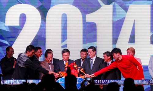 Representatives light a torch Wednesday at the opening ceremony for the 2014 IAAF Diamond League Shanghai. Chinese pole vaulter Yang Yansheng (second from the left) and 110-meter hurdler Xie Wenjun attended the ceremony. The track and field competition will start on May 18 at Shanghai Stadium. Photo: Yang Hui/GT