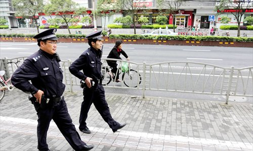 Two officers from the Jiangsu Road police station patrol carrying their side arms Sunday. Photo: Yang Hui/GT 