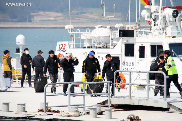 South Korean coast guard officers and divers get off the boat after a search mission in Jindo on April 22, 2014. Death toll in the South Korean ferry sinking accident surged on Tuesday night to 121 as divers were intensively searching inside the submerged hull. (Xinhua/Peng Qian)