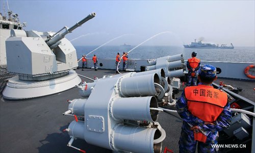 Soldiers on the Chinese naval ship put out a fire on another ship during the multi-country maritime exercises off the coast of Qingdao, east China's Shandong Province, April 23, 2014. Photo: Xinhua