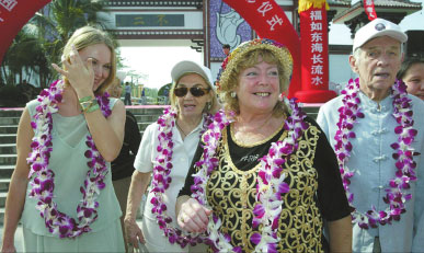 Foreign tourists take a picture with locals in Nanshan, Sanya, where people are renowned for their longevity.