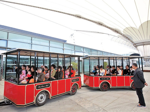 Visitors take a mini-train ride at a shopping center created from converted structures built for the 2010 Shanghai World Expo. The Expo Axis shopping center in the Pudong New Area, which opened to the public yesterday, is the biggest in Shanghai. — Wang Rongjiang 