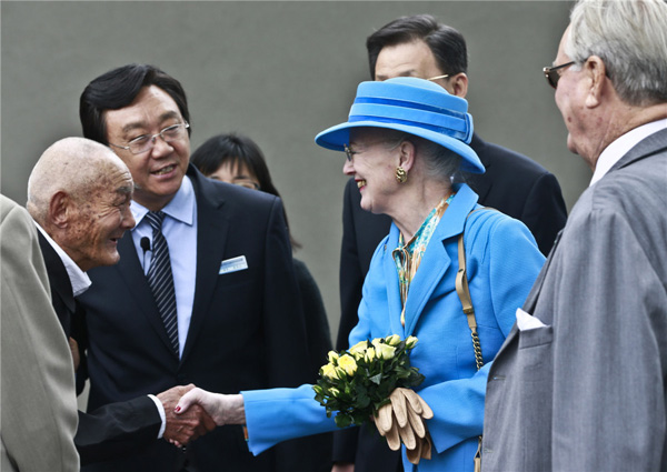 Queen Margrethe II of Denmark shakes hands with a survivor of the Nanjing massacre during her visit to the Memorial Hall of the Victims in Nanjing Massacre by Japanese Invaders, in Nanjing, capital of east China's Jiangsu province, April 27. [Feng Yongbin/China Daily]
