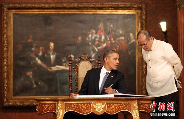 US President Barack Obama chats with Philippine counterpart Benigno Aquino as he signs the guest book at the Malacanang Palace in Manila on Monday, April 28, 2014. [Photo/China News Service]