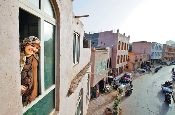 A woman at her new home in downtown Kashgar after renovation of the old residential areas. Jin Wei / For China Daily