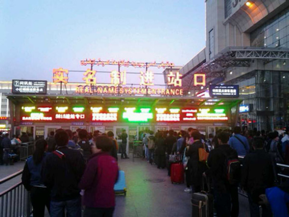People wait at an entrance to the south railway station of Urumqi, capital of northwest China's Xinjiang Uygur Autonomous Region, after an explosion on April 30. People in the square in front of the station and nearby were evacuated immediately after the blast, and police cordoned off all entrances to the square of the station. [Photo by Gao Bo/China Daily]