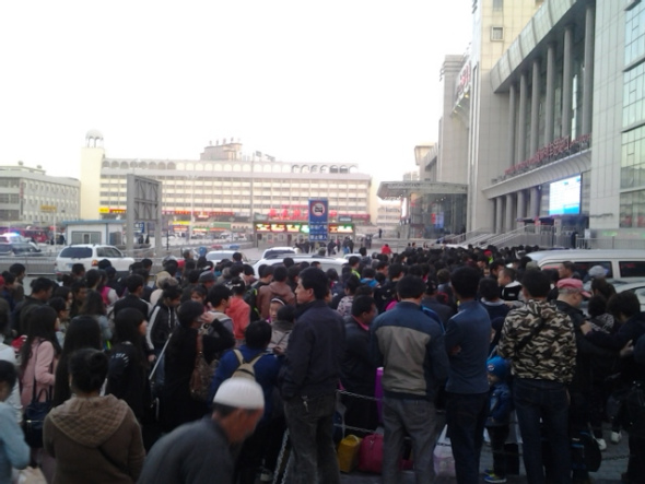 Crowds of people gather at an entrance to the south railway station of Urumqi, capital of northwest China's Xinjiang Uygur Autonomous Region, after an explosion on April 30. People in the square in front of the station and nearby were evacuated following the blast, and police cordoned off all entrances to the square of the station. [Photo by Gao Bo/China Daily]